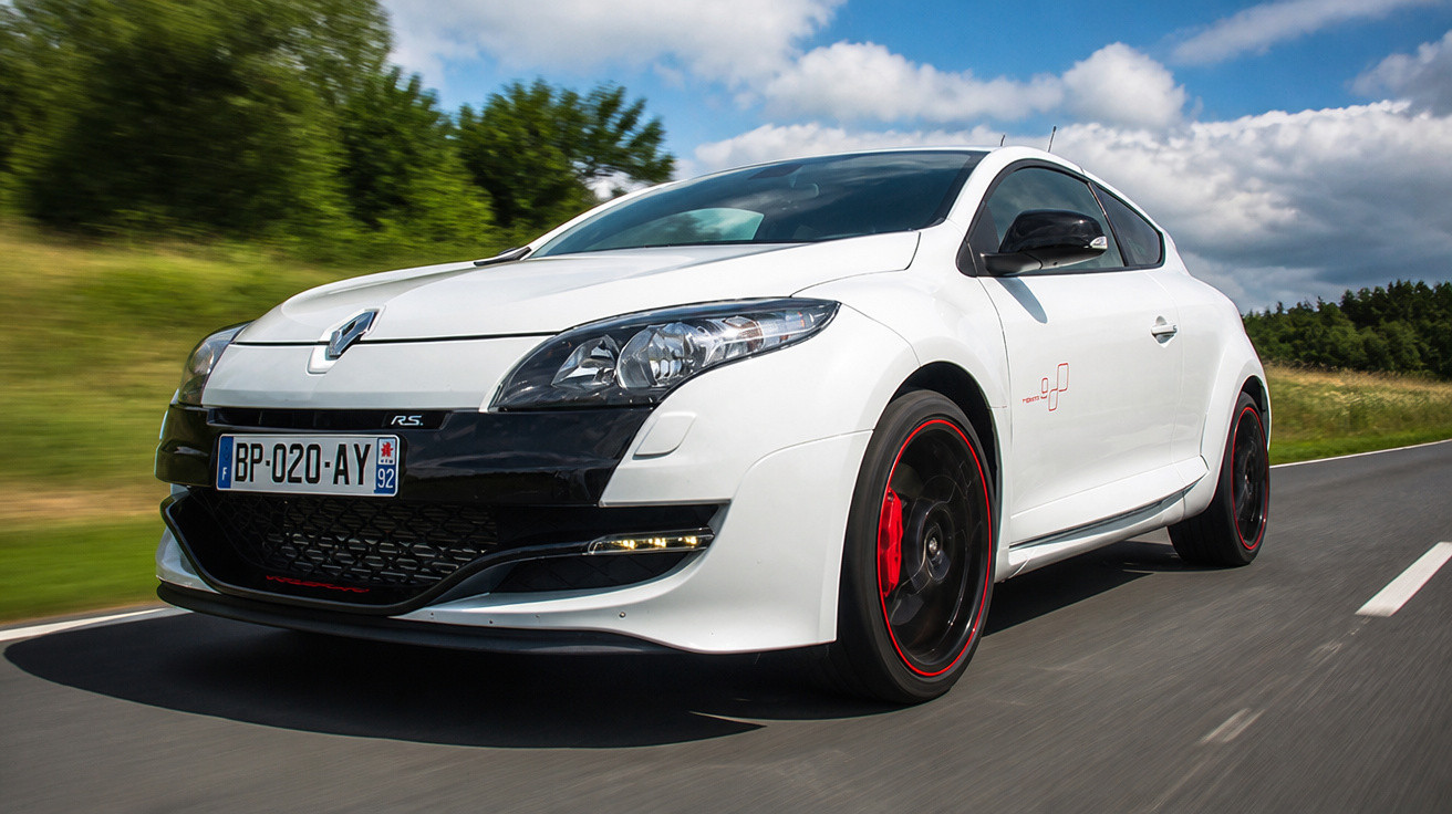 Carro desportivo branco Renault RS em estrada sob céu parcialmente nublado.